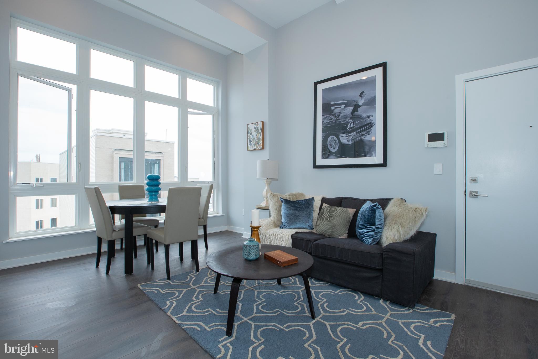 1534 Ridge Avenue, Unit 301 Philadelphia, PA 19130 - Photo 2 of 16 a living room with furniture two window and a dining table