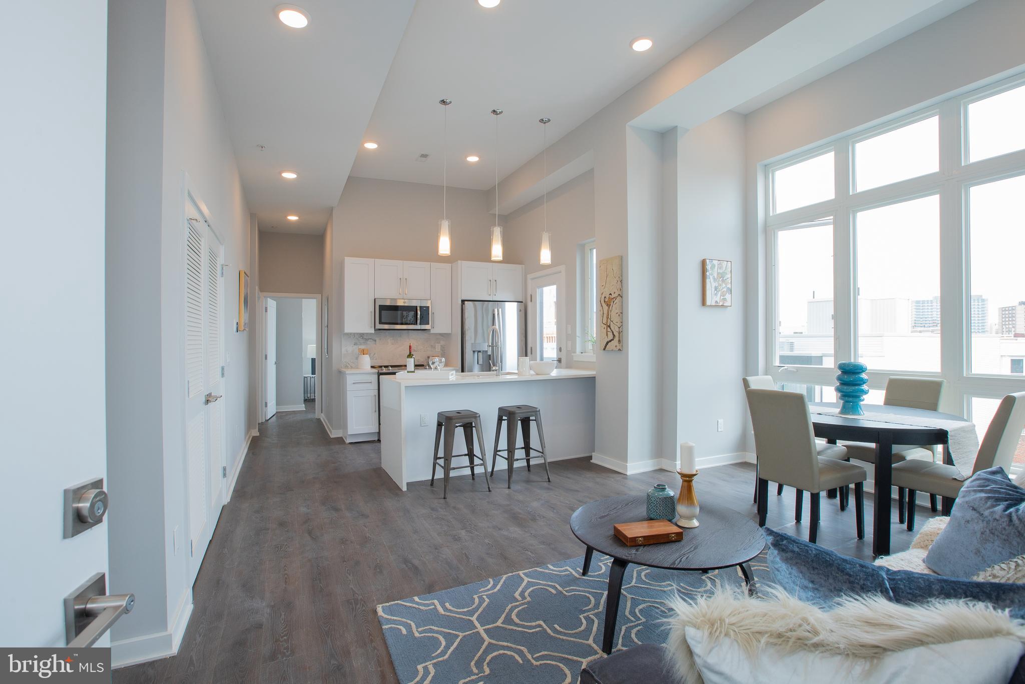 1534 Ridge Avenue, Unit 301 Philadelphia, PA 19130 - Photo 5 of 16 a living room with furniture and a dining table with kitchen appliances