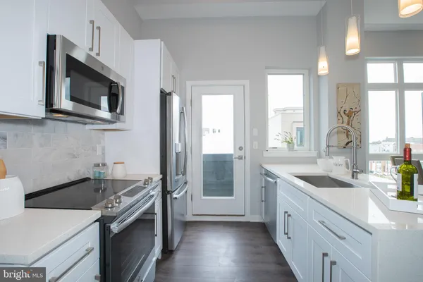 a kitchen with stainless steel appliances granite countertop a sink stove and microwave
