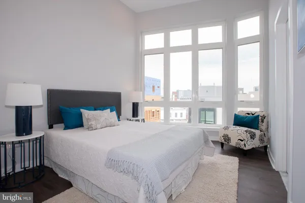 a bedroom with a bed couch and a large window