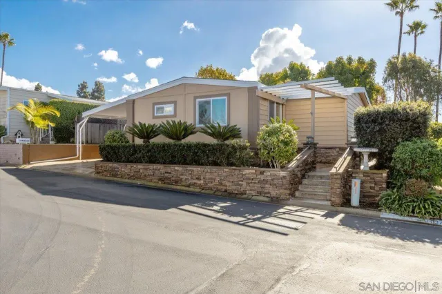 a front view of a house with a yard and potted plants