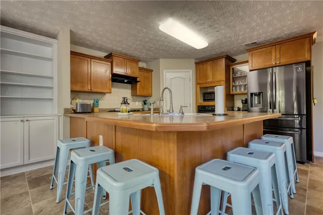 a kitchen with stainless steel appliances a sink cabinets and wooden floor