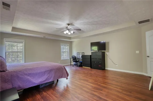 a bedroom with a bed and a flat tv screen on dresser