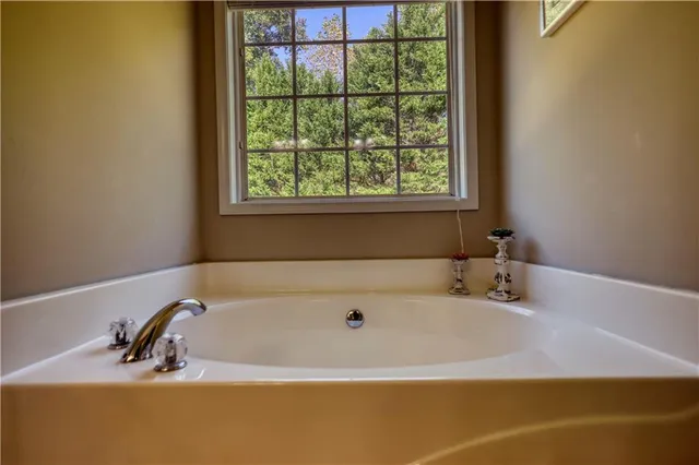 a bedroom with a bed and a lamp on dresser