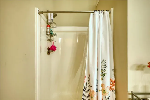a bedroom with a bed computer on desk and a printer on the dresser