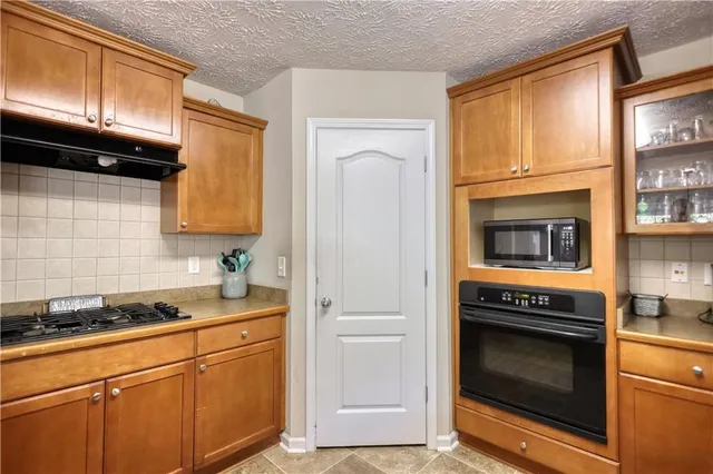 a kitchen with granite countertop cabinets stainless steel appliances and a window