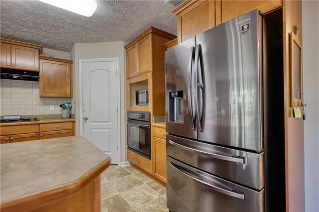 a kitchen with granite countertop a refrigerator and a sink