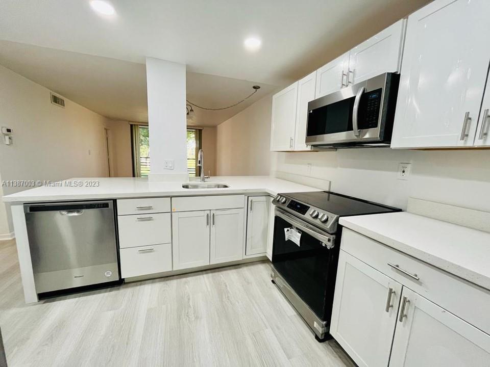 a kitchen with a sink stove and microwave