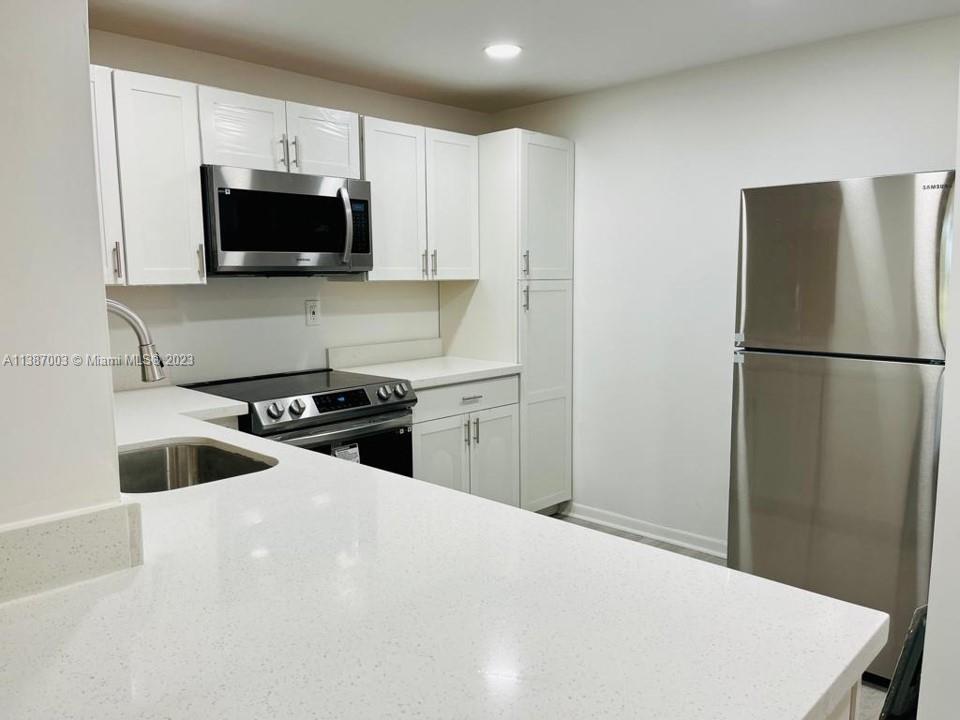 7950 West McNab Road, Unit 222 Tamarac, FL 33321 - Photo 11 of 35 a kitchen with a refrigerator and a sink