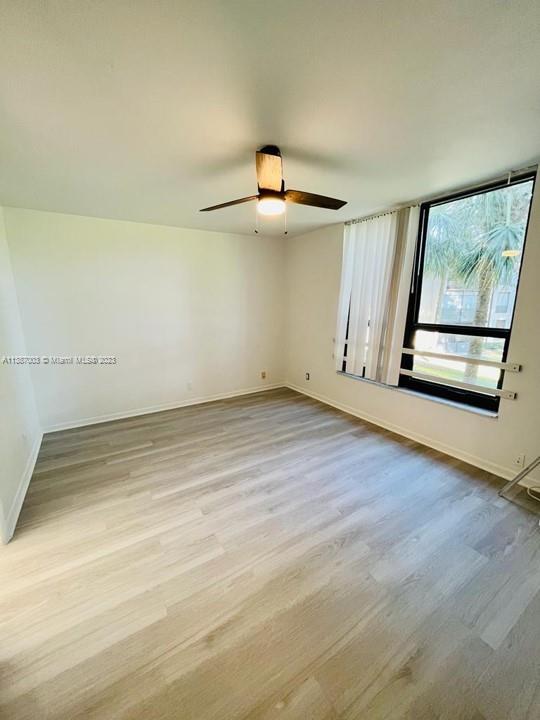 7950 West McNab Road, Unit 222 Tamarac, FL 33321 - Photo 17 of 35 an empty room with wooden floor cabinet and windows
