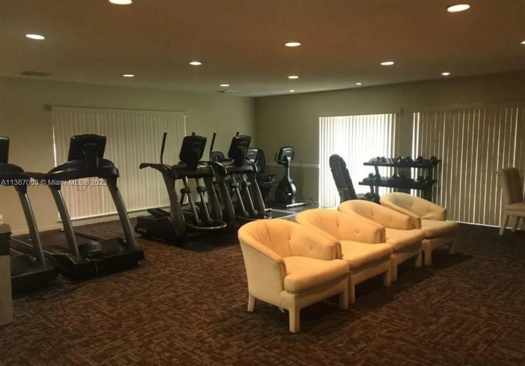 7950 West McNab Road, Unit 222 Tamarac, FL 33321 - Photo 29 of 35 a dinning room with furniture a rug and a projector