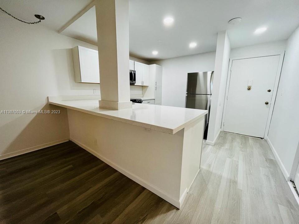 7950 West McNab Road, Unit 222 Tamarac, FL 33321 - Photo 8 of 35 a large white kitchen with wooden floor