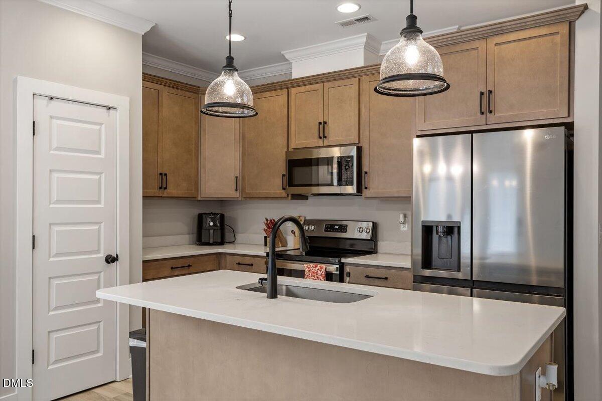 2810 Antioch Church Road Timberlake, NC 27583 - Photo 16 of 34 a kitchen with stainless steel appliances a sink a refrigerator center island a stove cabinets and stainless steel appliances