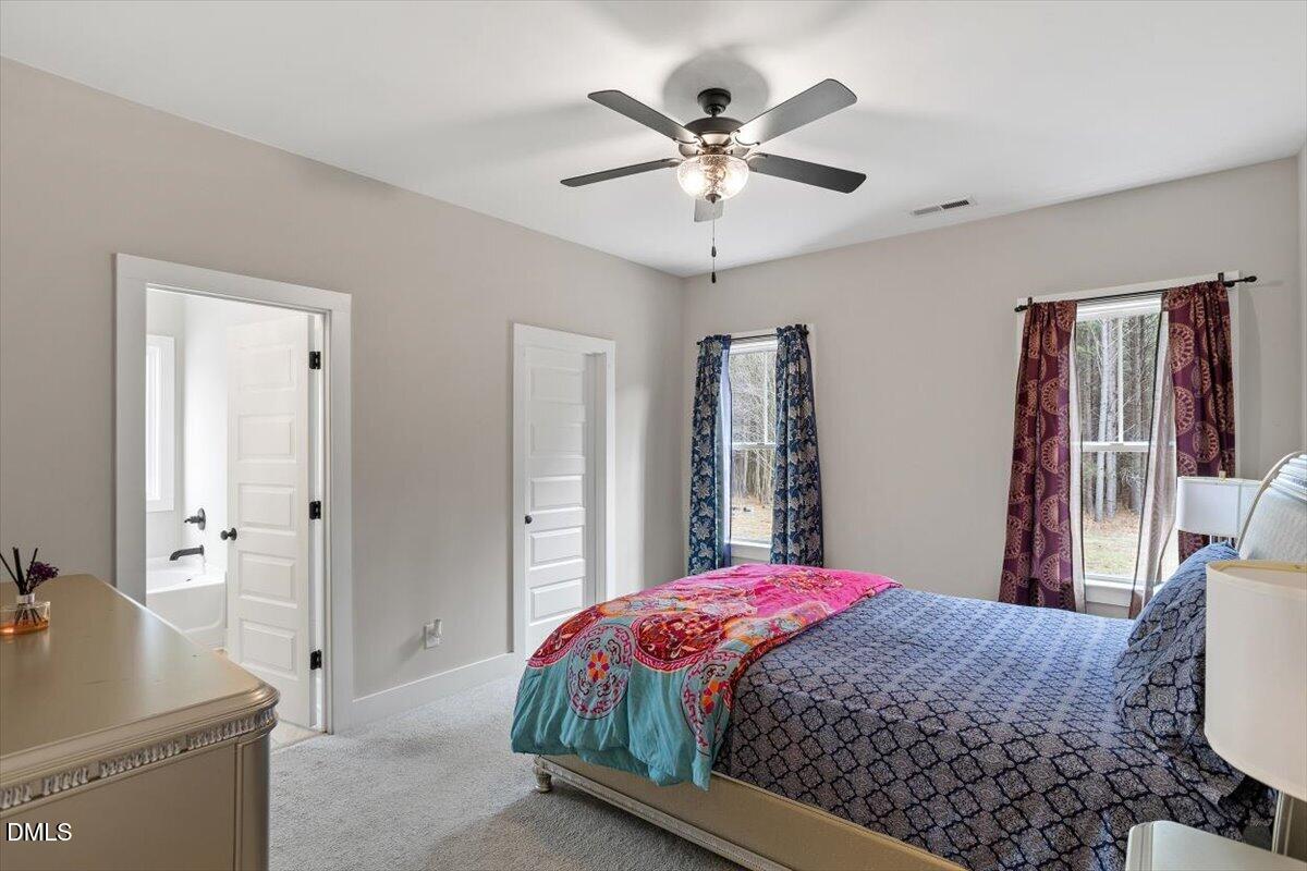 2810 Antioch Church Road Timberlake, NC 27583 - Photo 24 of 34 a bedroom with a large bed and a chandelier