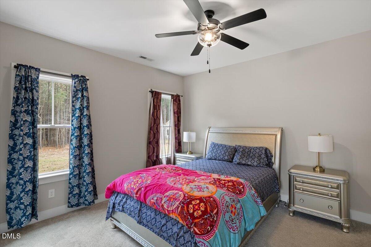 2810 Antioch Church Road Timberlake, NC 27583 - Photo 25 of 34 a bedroom with a bed and a chandelier