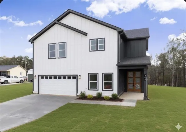 an empty room with wooden floor a ceiling fan and kitchen view