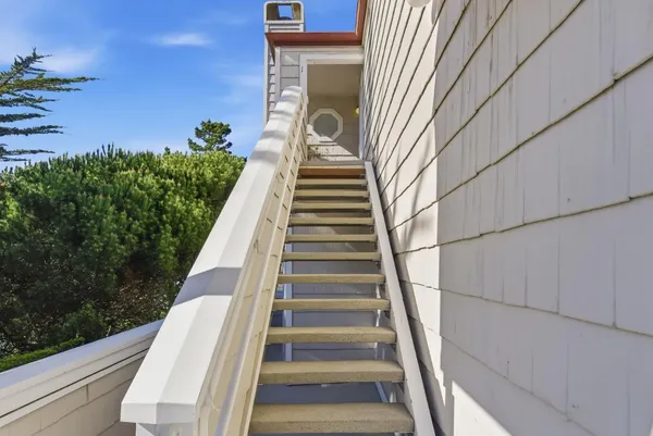 a living room with furniture a fireplace and potted plants with wooden floor