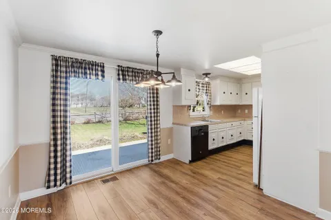 a kitchen with stainless steel appliances a sink and a wooden floor