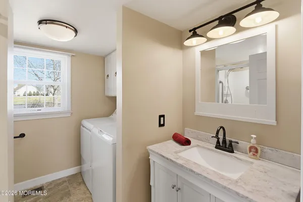a bathroom with a sink vanity granite toilet and a mirror