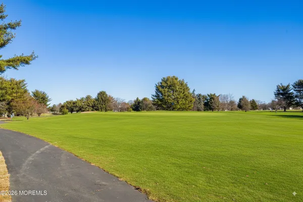 a view of a swimming pool with a lawn chairs under an umbrella