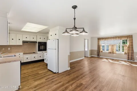 a kitchen with stainless steel appliances granite countertop a sink a stove and a wooden floors