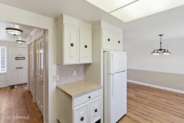 a kitchen with a refrigerator a sink and wooden floor