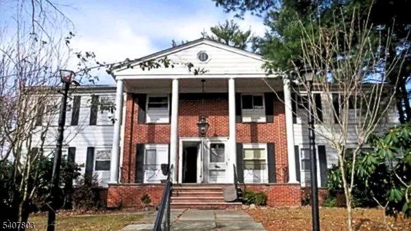 front view of a brick house with a small yard
