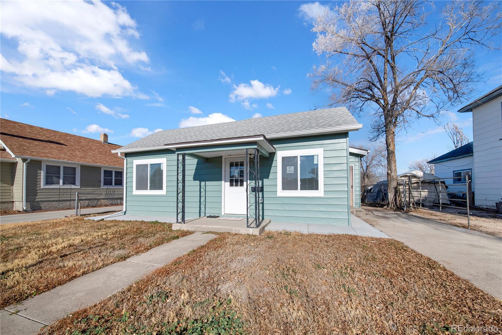 222 Platte Street Sterling, CO 80751 - Photo 2 of 24 a front view of a house with a yard and garage