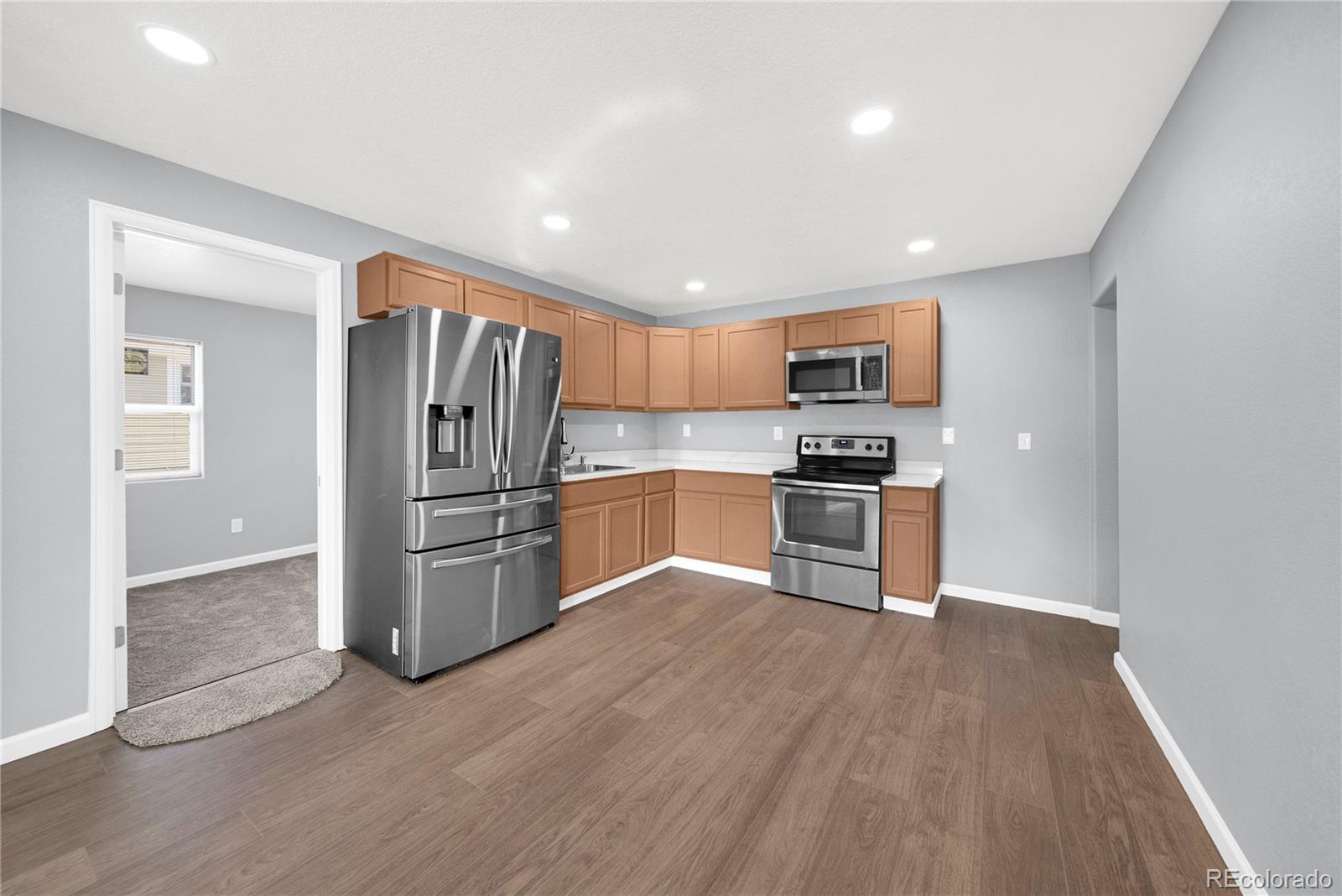 222 Platte Street Sterling, CO 80751 - Photo 8 of 24 a kitchen with granite countertop a refrigerator and a stove top oven
