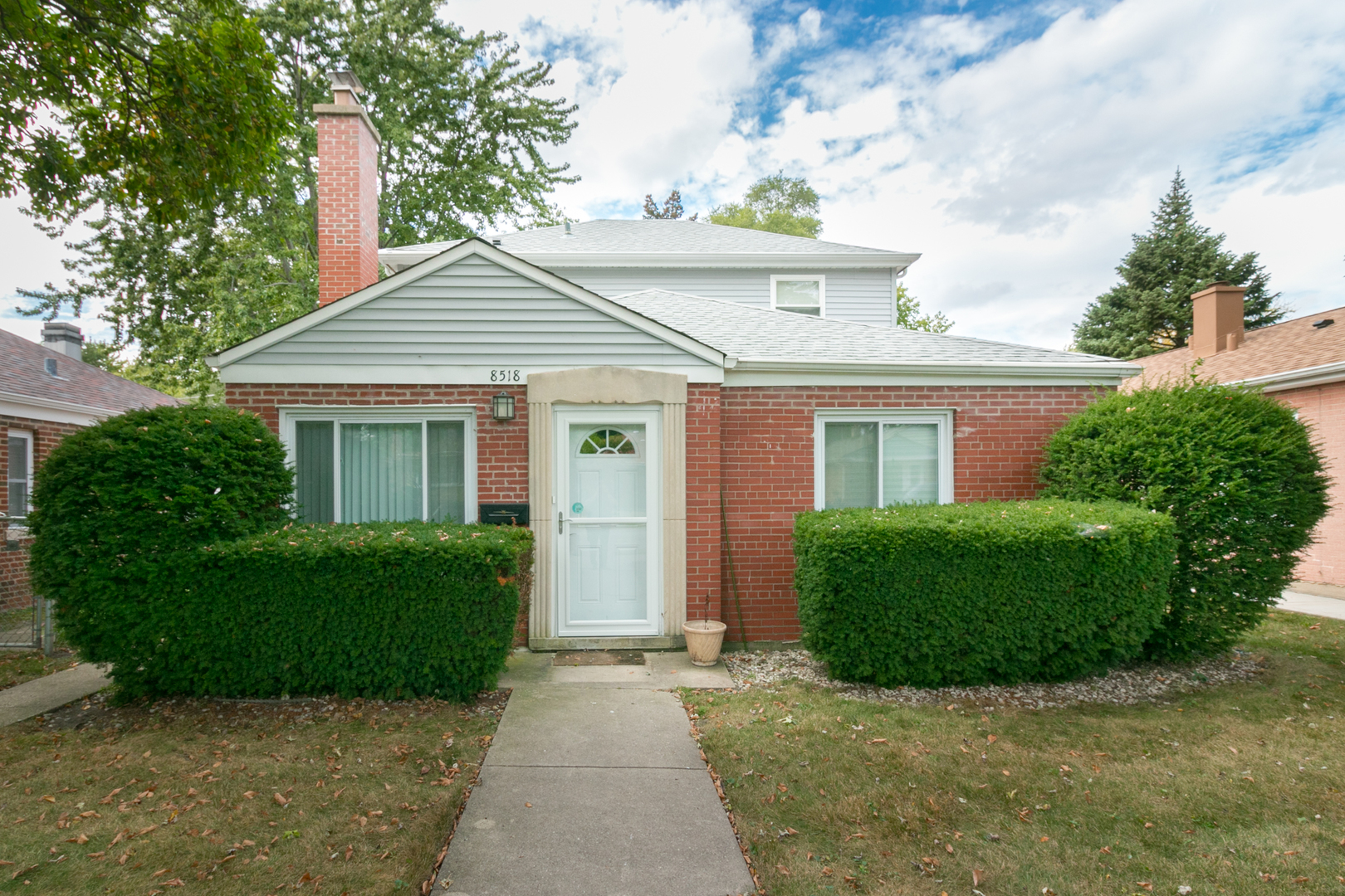 a front view of a house with a garden