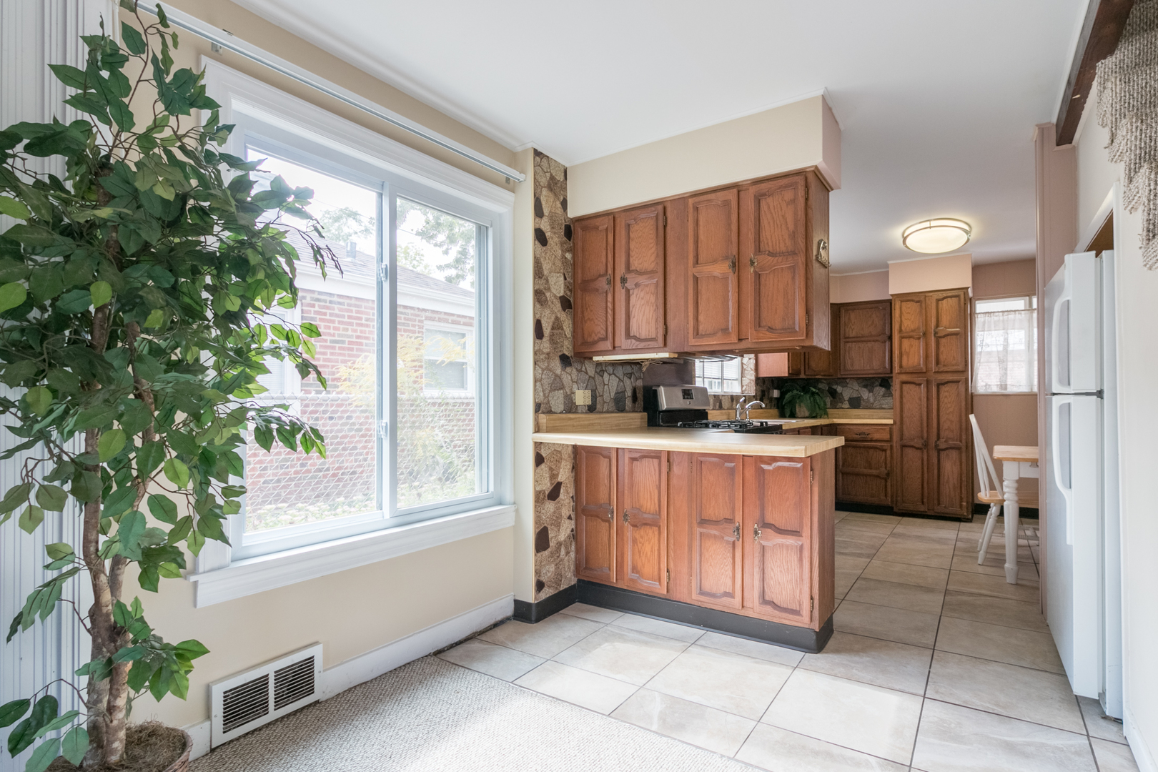8518 East Prairie Road Skokie, IL 60076 - Photo 3 of 17 a kitchen with a refrigerator and a stove top oven
