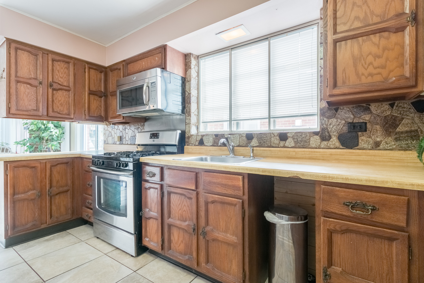 8518 East Prairie Road Skokie, IL 60076 - Photo 5 of 17 a kitchen with stainless steel appliances granite countertop a sink and a stove