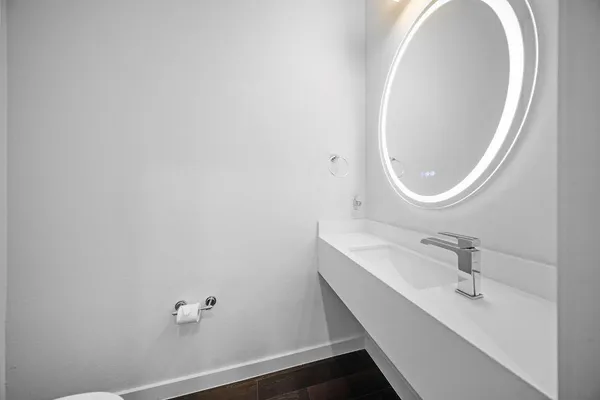 a view of a hallway with wooden floor and washer dryer