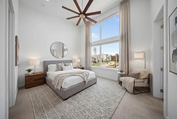 an empty room with a window and a ceiling fan