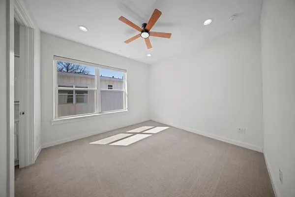 en empty room with windows and ceiling fan