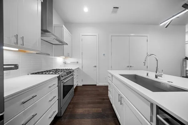 a kitchen with sink stove and cabinets
