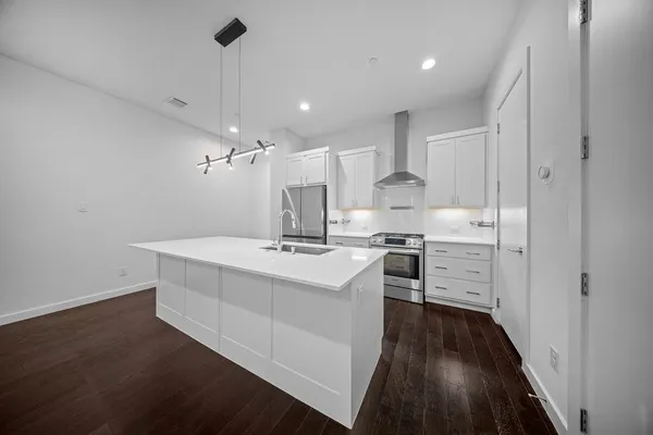 a kitchen with stove and wooden floor