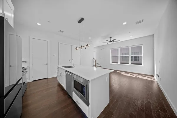 a kitchen with a stove a sink and wooden floor