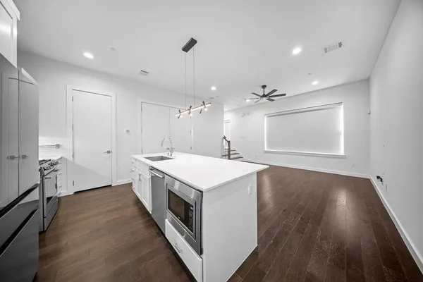 a kitchen with a sink and wooden floor