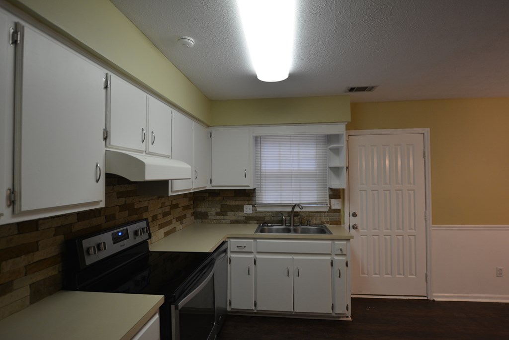 9 Lott Road Phenix City, AL 36869 - Photo 3 of 23 a kitchen with granite countertop white cabinets and black appliances