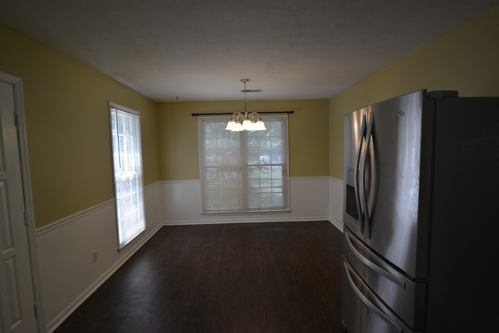 9 Lott Road Phenix City, AL 36869 - Photo 4 of 23 a view of a refrigerator in kitchen and an empty room with wooden floor windows