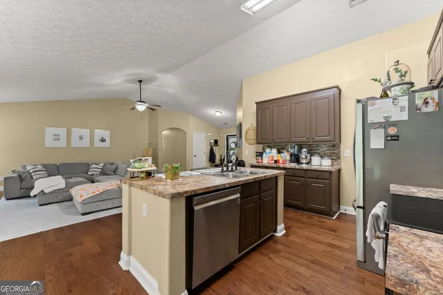a kitchen with stainless steel appliances granite countertop a sink stove and refrigerator