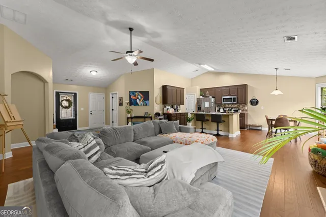 a living room with furniture and a wooden floor