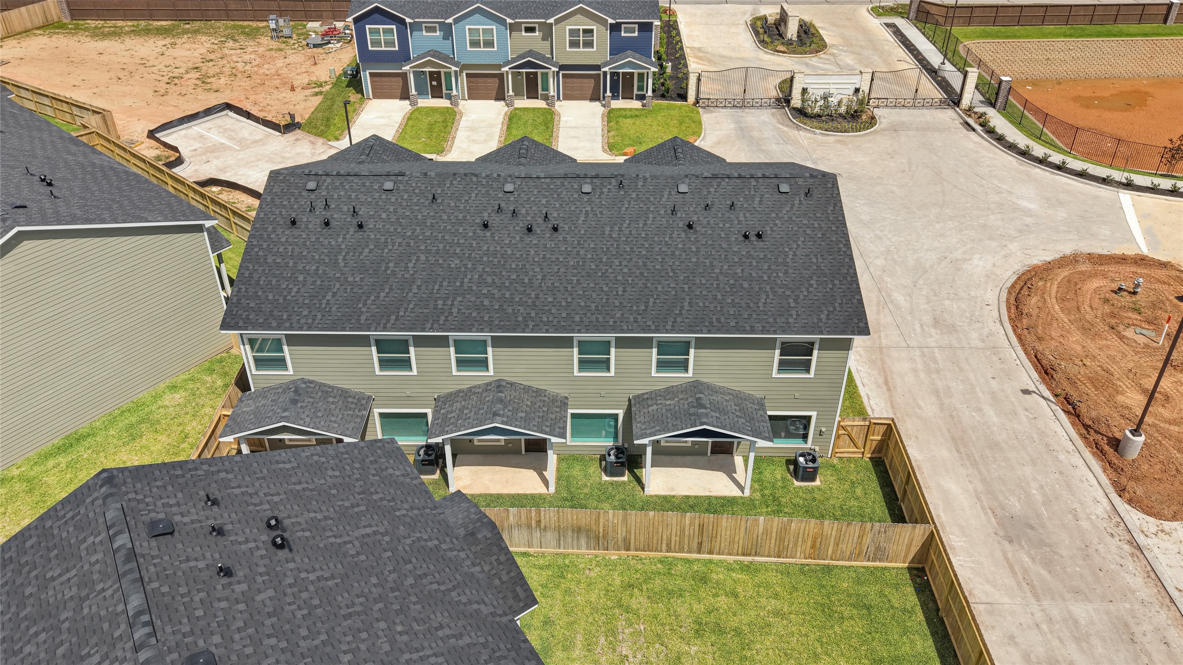 14010 Longstreet Road, Unit 2 Willis, TX 77318 - Photo 6 of 29 This aerial view shows a modern townhouse with a dark roof and fenced backyard. It's part of a new development, featuring multiple similar homes and a clean, landscaped area. Ideal for buyers seeking a contemporary, community-oriented living space.
