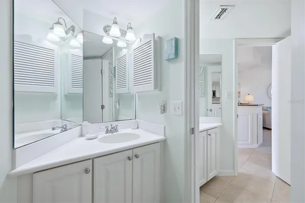 a en suite bathroom with a granite countertop sink and a mirror