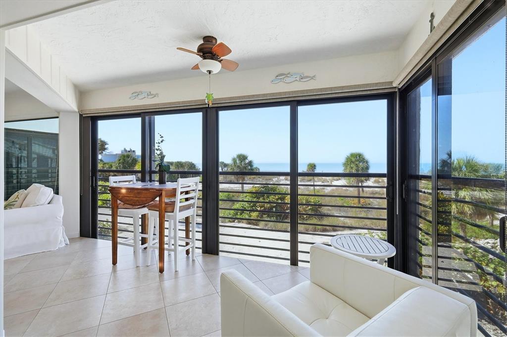 5000 Gasparilla Road, Unit BC205 Boca Grande, FL 33921 - Photo 21 of 50 a living room with couches and a dining table with balcony view