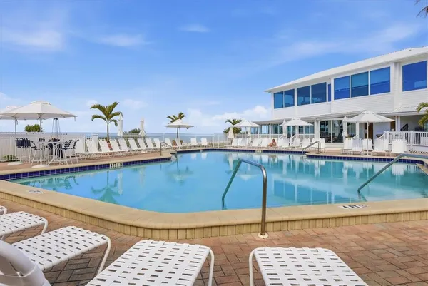 a view of a chairs and table on wooden deck with lake view