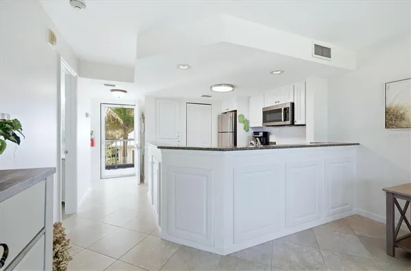 a large white kitchen with cabinets and stainless steel appliances