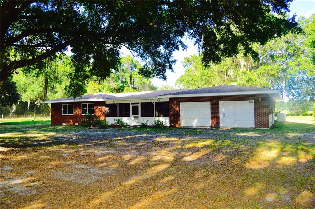 1301 Loop Road Auburndale, FL 33823 - Photo 1 of 1 a view of a yard in front of a house with large trees