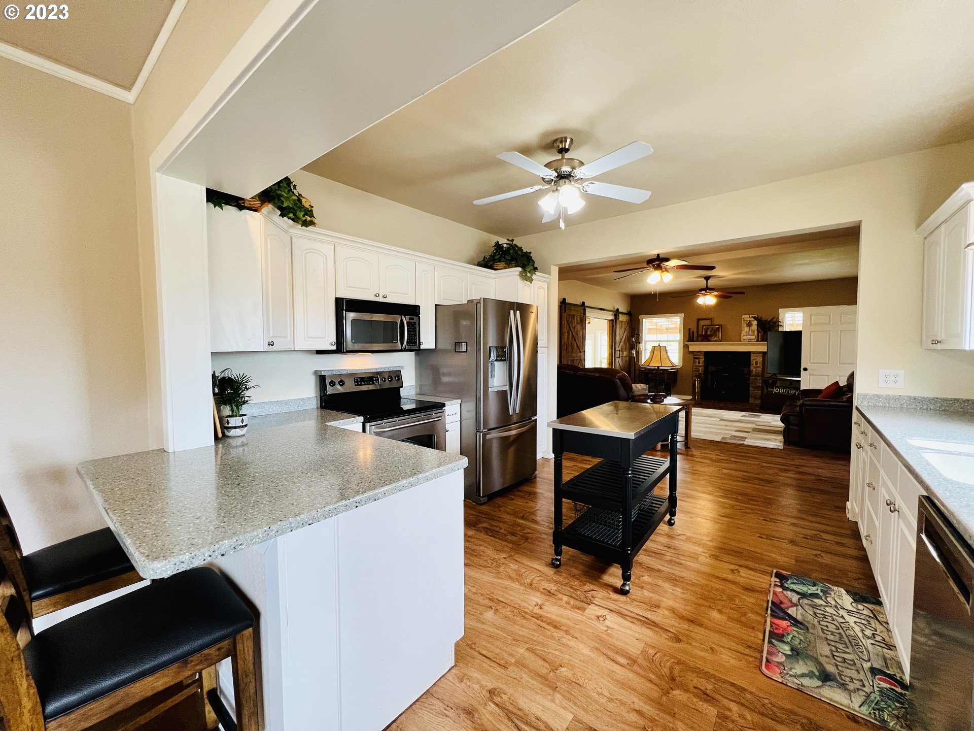 5393 Nonpareil Road Sutherlin, OR 97479 - Photo 12 of 42 a living room with stainless steel appliances kitchen island granite countertop a table chairs and a refrigerator